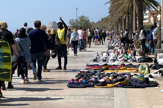 Street vendors display their goods to crowds of people walking along the shorefront in Sitges, March 28, 2021 (by Gemma Sánchez)